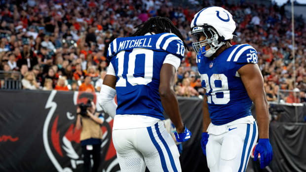 Colts receiver Adonai Mitchell (blue jersey with white pants) celebrates a touchdown with a teammate. 