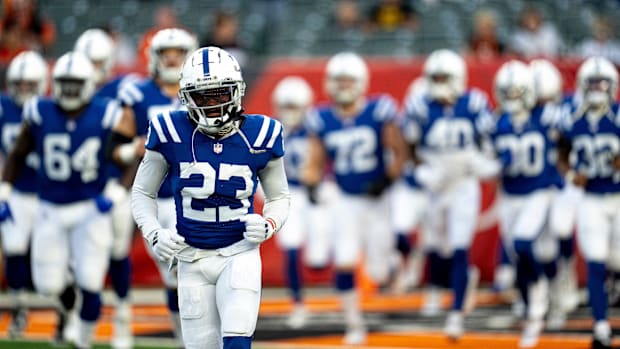 Colts cornerback Kenny Moore II (blue jersey; white helmet/pants) walks onto the field with the rest of his teammates. 