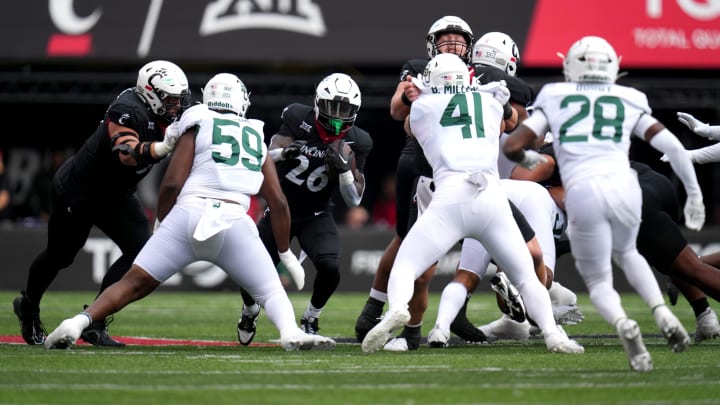 Cincinnati Bearcats running back Myles Montgomery (26) carries the ball as the offensive line blocks in the first quarter during a college football game between the Baylor Bears and the Cincinnati Bearcats, Saturday, Oct. 21, 2023, at Nippert Stadium in Cincinnati.