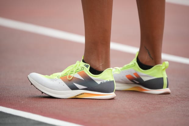 Gabby Thomas' yellow and white New Balance spikes.