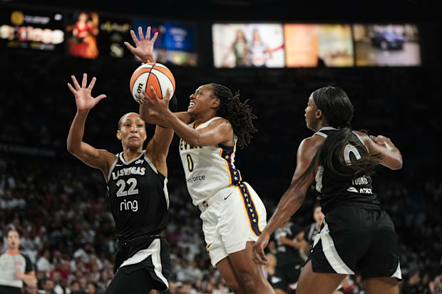 Fever guard Kelsey Mitchell attempts to score a layup against Las Vegas Aces center A'ja Wilson and guard Jackie Young