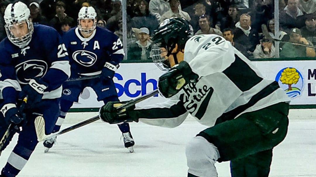 Michigan State's Porter Martone (22) shoots the puck past defenders and Penn State goaltender Josh Fleming (34) late in the first period at Munn Ice Arena Saturday, Nov. 8, 2025.