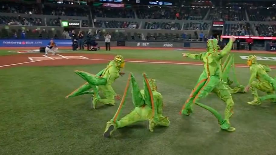A group of people in cricket costumes throw the ceremonial first pitch before the Toronto Blue Jays game against the San Diego Padres.  | Screenshot via Jomboy Media on X