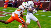 Nov 22, 2025; Blacksburg, Virginia, USA; Virginia Tech Hokies running back Jeffrey Overton (16) runs in for the touchdown against Miami (FL) Hurricanes defensive back Dylan Day (23) during the third quarter at Lane Stadium. Mandatory Credit: Neville E. Guard-Imagn Images