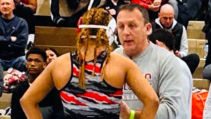 Taina Fernandez discusses strategy with coach Brian Leitzel at the MIAA Championships, where she made history as the tournament's first female champion.