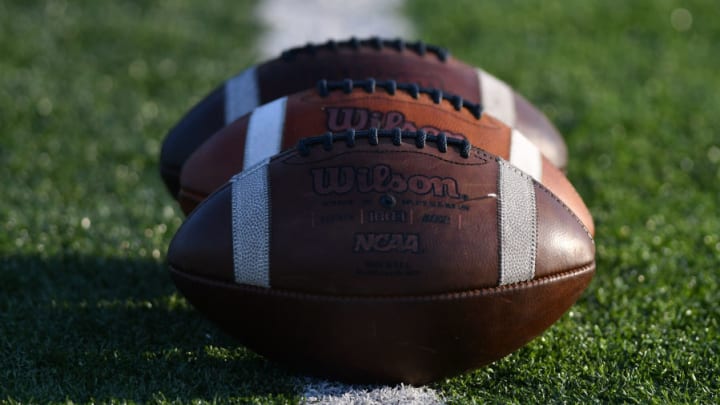 Three footballs on a football field