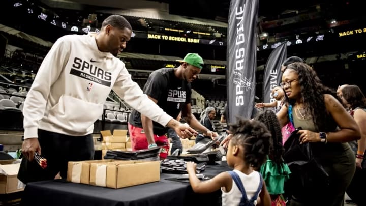 Aug 5, 2023; San Antonio, Texas, USA; San Antonio Spurs guard Malaki Branham (22) and center Charles Bassey (28) give school supplies to those in attendance at the team-sanctioned Back to School Bash at Frost Bank Center.