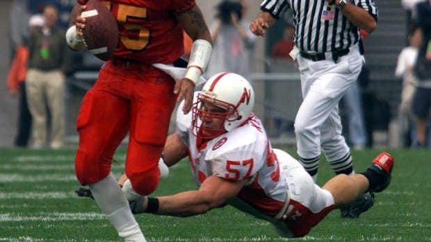 Iowa State quarterback Seneca Wallace sprints in the open field as Chris Kelsay's tackle attempt fails for Nebraska.