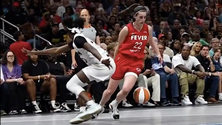 Indiana Fever point guard Caitlin Clark dribbles past Atlanta Dream guard Maya Caldwell.