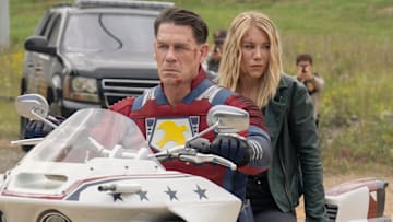 John Cena as Christopher Smith / Peacemaker and Jennifer Holland as Emilia Harcourt in Peacemaker season 2. 