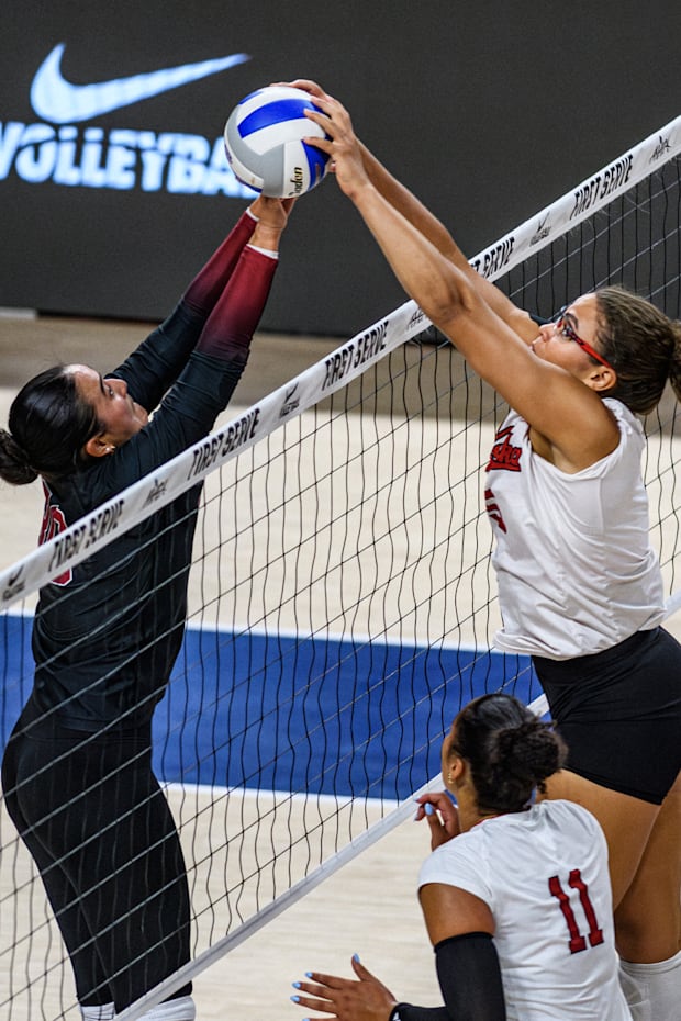 Nebraska's Rebekah Allick fights to get the ball over the net with a Stanford defender. 