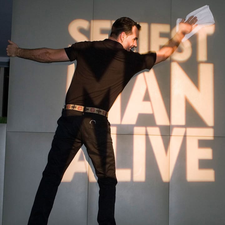 A man is pictured in front of a 'Sexiest Man Alive' sign