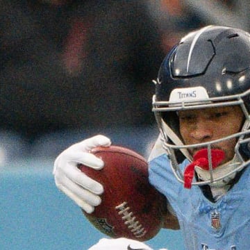 Los Angeles Chargers linebacker Daiyan Henley tackles Tennessee Titans wide receiver Chimere Dike.