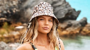 Ellie Thumann was photographed by Ben Watts in Bermuda. Swimsuit top by Andi Bagus. Swimsuit bottom by Lybethras. Shorts by KSUBI. Hat by Eugenia Kim.