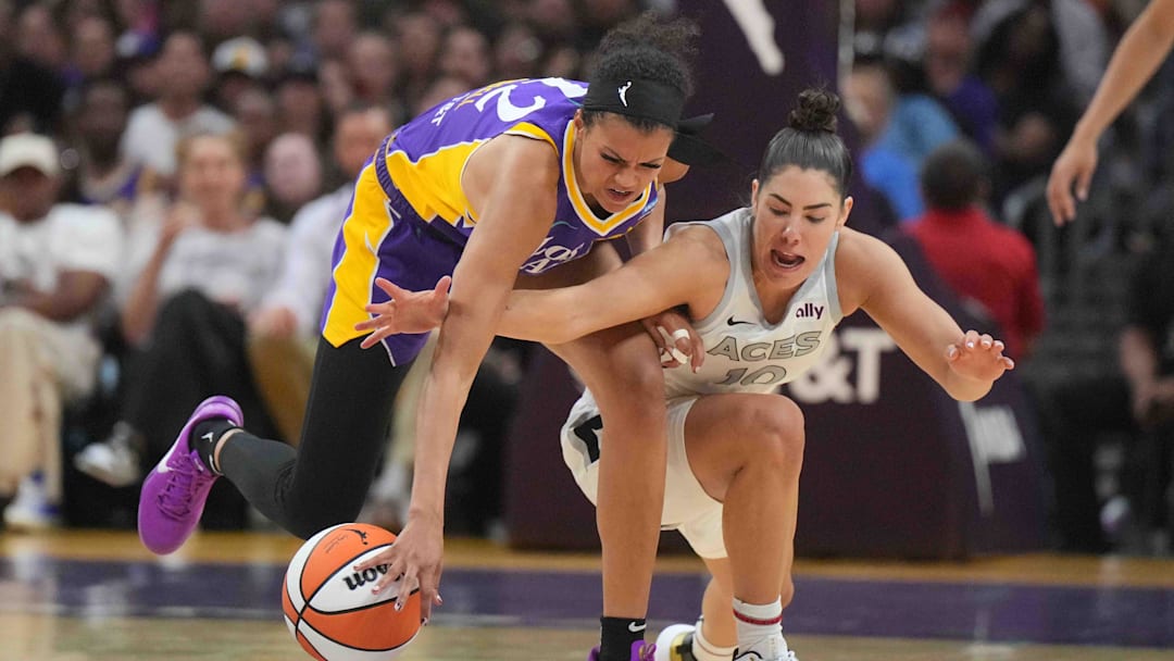 Jul 5, 2024; Los Angeles, California, USA: LA Sparks guard Rae Burrell (12) and Las Vegas Aces guard Kelsey Plum (10) reach for the ball in the second half at Crypto.com Arena. Mandatory Credit: Kirby Lee-Imagn Images