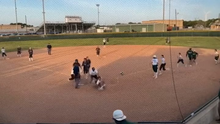 Mathis (Texas) softball coach Briana Cruz (falling) and a Taft player fall to the ground together behind home plate after Cruz raced in from the dugout and became entangled with the Taft player during a skirmish between the clubs on Tuesday. 