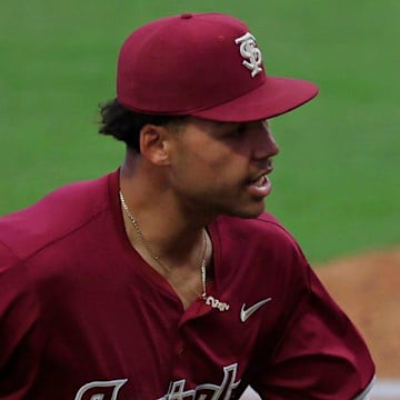 Florida State first baseman Daniel Cantu (32), right, is patted on the back by infielder Cam Smith (24) during the fourth inning of an NCAA baseball matchup at 121 Financial Ballpark in Jacksonville, Fla. Florida State defeated Florida 14-3.