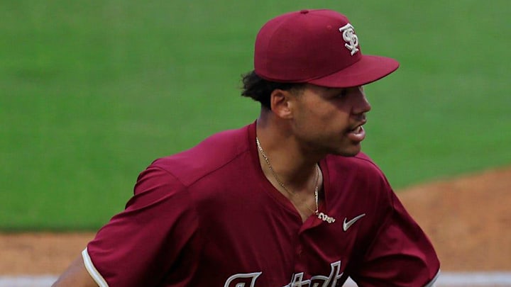 Florida State first baseman Daniel Cantu (32), right, is patted on the back by infielder Cam Smith (24) during the fourth inning of an NCAA baseball matchup at 121 Financial Ballpark in Jacksonville, Fla. Florida State defeated Florida 14-3.