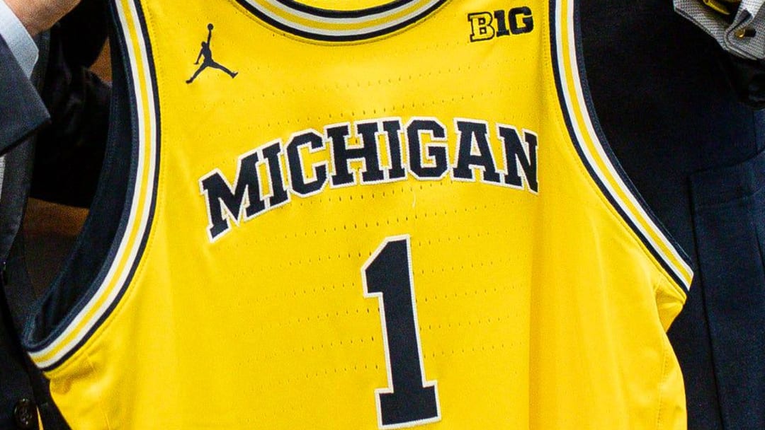 U-M athletic director Warde Manuel presents a jersey to new men's basketball head coach Dusty May