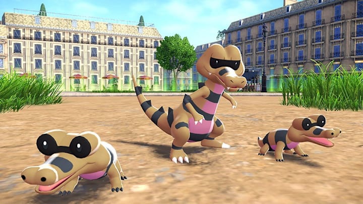 A Krokorok flanked by two Sandiles in a sandy area of a town.