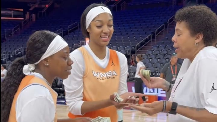 WNBA All-Star coach Cheryl Miller gives Angel Reese and Arike Ogunbowale cash for making half court shots in a contest at practice.