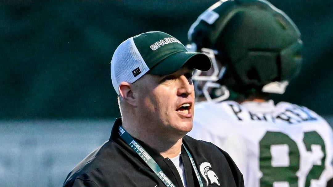 Michigan State's head coach Pat Fitzgerald, left, slaps hands with NiJhay Burt during spring football practice on Tuesday, April 14, 2026, in East Lansing.