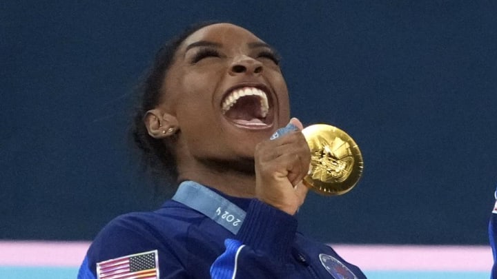 Jul 30, 2024; Paris, France; Simone Biles of the United States celebrates with her gold medal after the women’s team final at the Paris 2024 Olympic Summer Games at Bercy Arena. 