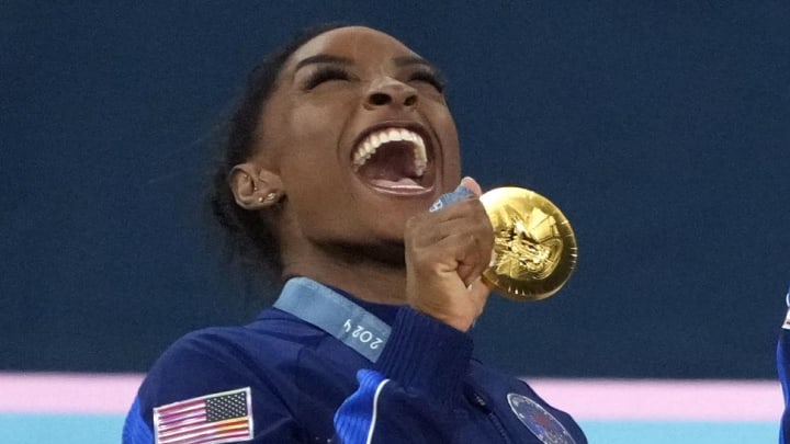 Jul 30, 2024; Paris, France; Simone Biles of the United States celebrates with her gold medal after the women’s team final at the Paris 2024 Olympic Summer Games at Bercy Arena.