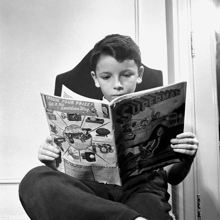 A child is pictured with a 'Superman' comic