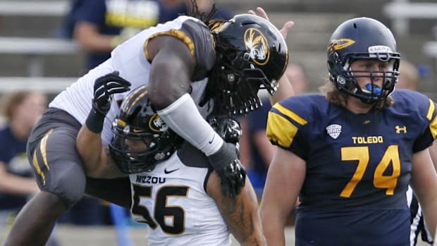 Missouri Tigers defensive lineman Markus Golden (33) jumps on defensive lineman Shane Ray (56)