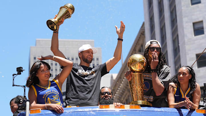 Jun 20, 2022; San Francisco, CA, USA; Golden State Warriors guard Stephen Curry (middle left) gestures while standing with wife Ayesha (far left) and guard Damion Lee (middle right) and his wife Sydel Curry (far right) during the Golden State Warriors championship parade in downtown San Francisco. Mandatory Credit: Darren Yamashita-USA TODAY Sports