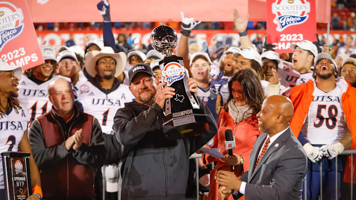 UTSA head coach Jeff Traylor is presented the trophy after winning the Frisco Bowl.