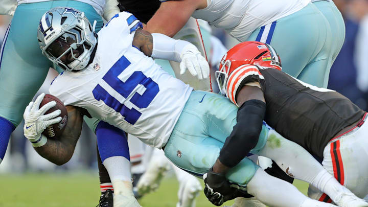 Dallas Cowboys running back Ezekiel Elliott (15) is wrapped up by Cleveland Browns linebacker Jeremiah Owusu-Koramoah (6) during the second half of an NFL football game at Huntington Bank Field.