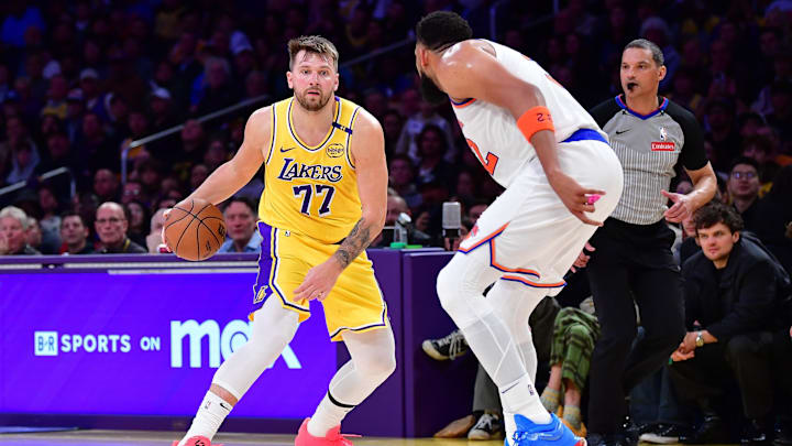 Mar 6, 2025; Los Angeles, California, USA; Los Angeles Lakers guard Luka Doncic (77) moves the ball against New York Knicks center Karl-Anthony Towns (32) during the second half at Crypto.com Arena. Mandatory Credit: Gary A. Vasquez-Imagn Images