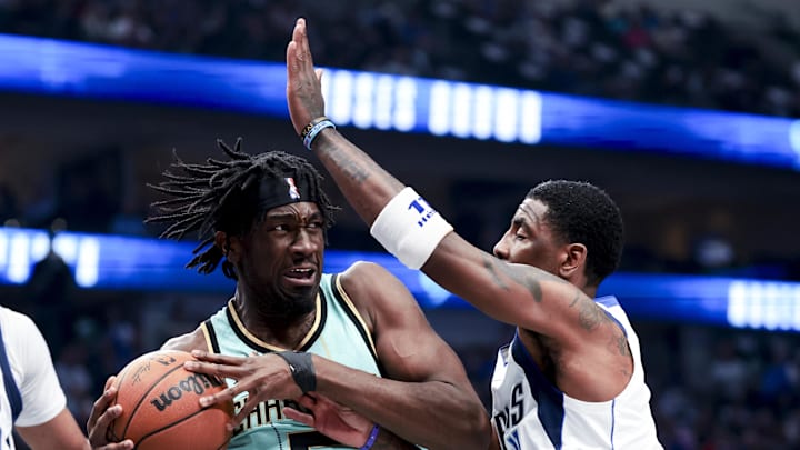 Feb 27, 2025; Dallas, Texas, USA;  Charlotte Hornets center Mark Williams (5) controls the ball as Dallas Mavericks guard Kyrie Irving (11) defends during the first half at American Airlines Center. Mandatory Credit: Kevin Jairaj-Imagn Images
