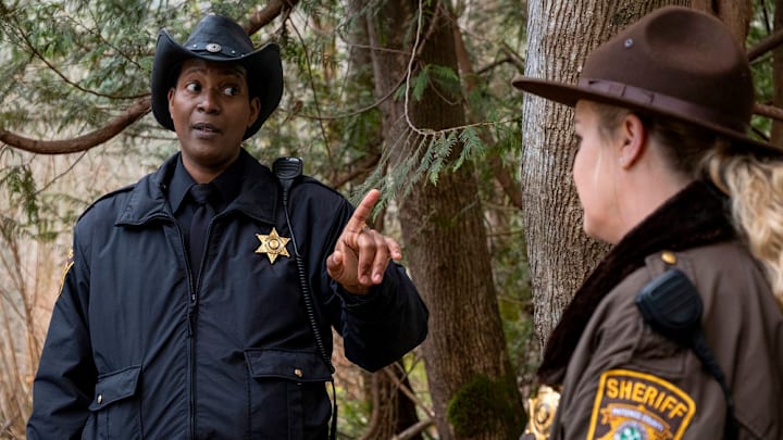 RESIDENT ALIEN -- "Daddy Issues" Episode 407 -- Pictured: (l-r) Corey Reynolds as Sheriff Mike Thompson, Elizabeth Bowen as Deputy Liv Baker -- (Photo by: James Dittiger/USA Network)