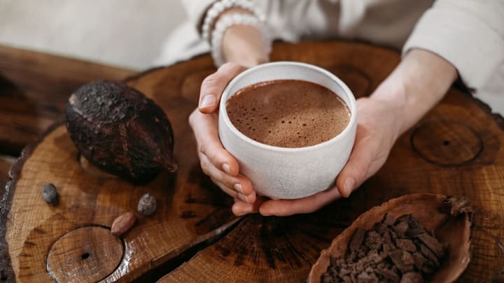 Cup of ceremonial cacao next to bean