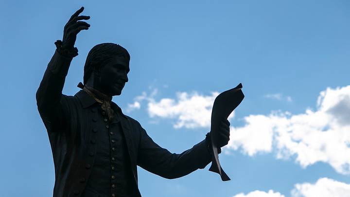 Silhouette of a reading of the Declaration of Independence against blue sky Silhouette of a reading of the Declaration of Independence against blue sky