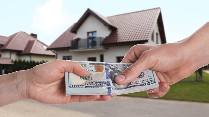Handing over hundred-dollar bills in front of suburban house Handing over hundred-dollar bills in front of suburban house