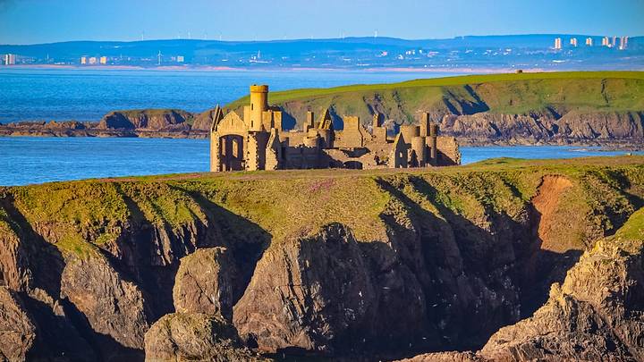 Slains Castle with Aberdeen city in the background, Cruden Bay, Aberdeenshire Slains Castle with Aberdeen city in the background, Cruden Bay, Aberdeenshire