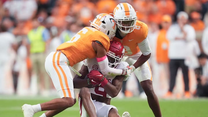 Tennessee defensive back Jalen McMurray (6) and Tennessee defensive back Colton Hood (8) tackle Arkansas wide receiver O’Mega Blake (9) during a college football game between Tennessee and Arkansas at Neyland Stadium in Knoxville, Tennessee on Oct. 11, 2025.