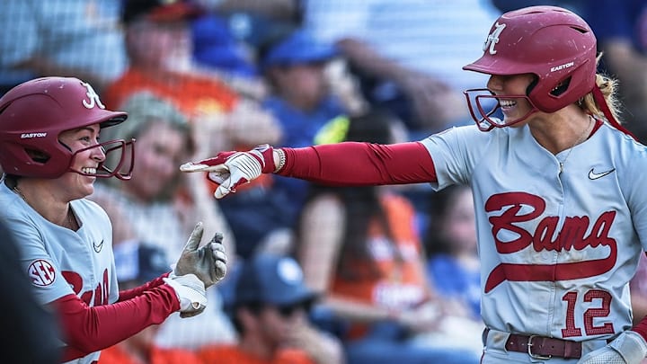 Alabama softball's Audrey Vandagriff smiles and points at her teammates after scoring a run against Florida.