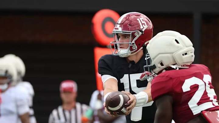 Ty Simpson (15) hands the football off to Jam Miller (26).