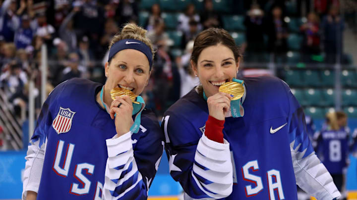 Team USA athlete, and former University of Wisconsin standouts, Meghan Duggan (left) and Hilary Knight celebrate after winning the gold medal in women's ice hockey during the 2018 Olympics.