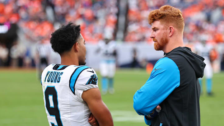 DENVER, COLORADO - OCTOBER 27: Andy Dalton #14 and Bryce Young #9 of the Carolina Panthers speak on the sidelines during the fourth quarter against the Denver Broncos at Empower Field At Mile High on October 27, 2024 in Denver, Colorado.