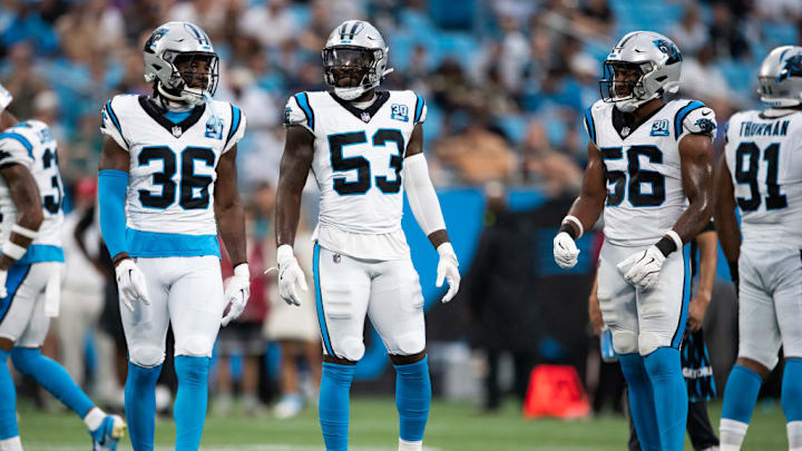 CHARLOTTE, NORTH CAROLINA - AUGUST 17: Devin Carter #36, Claudin Cherelus #53, and Trevin Wallace #56 of the Carolina Panthers prepare for a play during a preseason game against the New York Jets at Bank of America Stadium on August 17, 2024 in Charlotte, North Carolina.