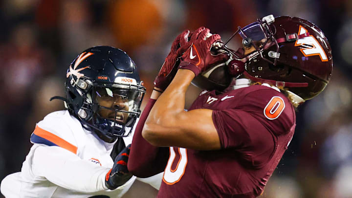 BLACKSBURG, VIRGINIA - NOVEMBER 30: Ali Jennings #0 of the Virginia Tech Hokies catches the ball over Jam Jackson #9 of the Virginia Cavaliers in the second half during a game at Lane Stadium on November 30, 2024 in Blacksburg, Virginia. 