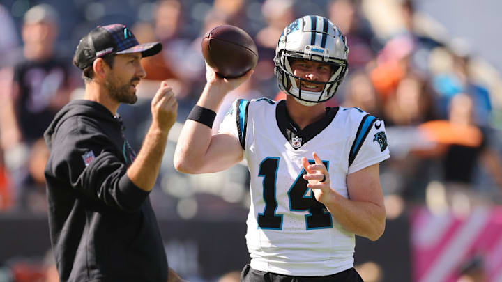 CHICAGO, ILLINOIS - OCTOBER 06: Andy Dalton #14 of the Carolina Panthers talks with passing game coordinator Nathan Carroll prior to the game against the Chicago Bears at Soldier Field on October 06, 2024 in Chicago, Illinois.