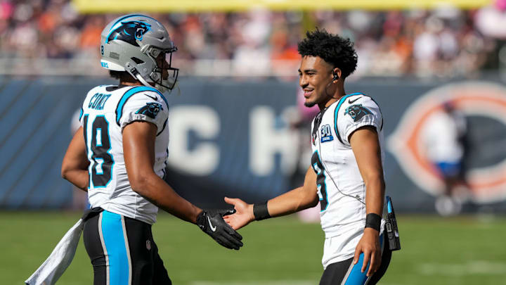 CHICAGO, ILLINOIS - OCTOBER 6: Quarterback Bryce Young #9 of the Carolina Panthers interacts with wide receiver Jalen Coker #18 on the field during the third quarter of an NFL football game against the Chicago Bears, at Soldier Field on October 6, 2024 in Chicago, Illinois.