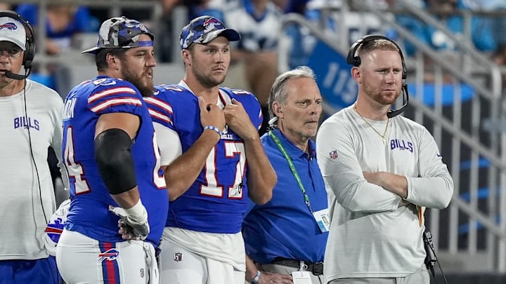 Aug 26, 2022; Charlotte, North Carolina, USA; Buffalo Bills guard Greg Van Roten (64), quarterback Josh Allen (17) and offensive coach Joe Brady watch as Carolina Panthers quarterback Sam Darnold (not pictured) is carted off the field during the second half at Bank of America Stadium. 